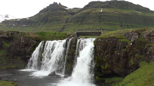 Scenic view of waterfall against sky