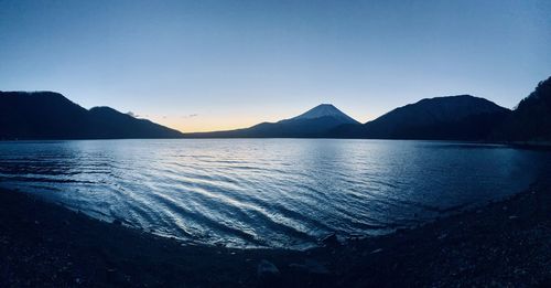 Scenic view of lake against clear sky during sunset