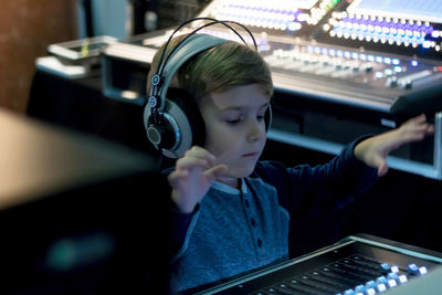 Close-up of boy using sound mixer in studio