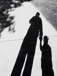 Shadow of man holding umbrella