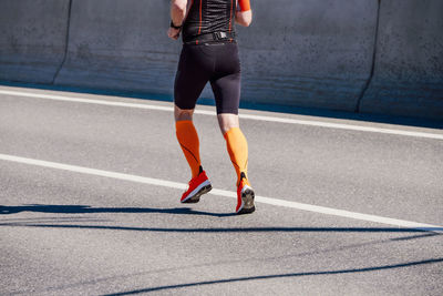 Low section of woman exercising on road