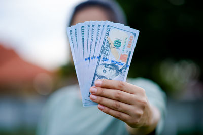 Midsection of man holding paper currency