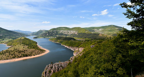 Scenic view of river amidst mountains against sky