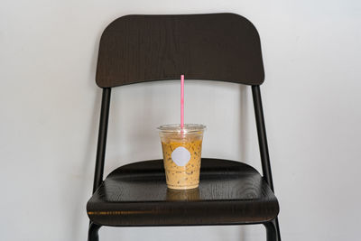 Close-up of drink in glass on table against wall