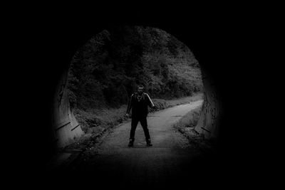 Rear view of person standing in tunnel