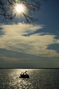 Silhouette boat in sea against sky during sunset