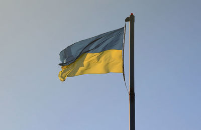 Low angle view of flag against clear sky