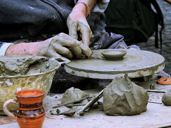 Midsection of craftsman making clay product