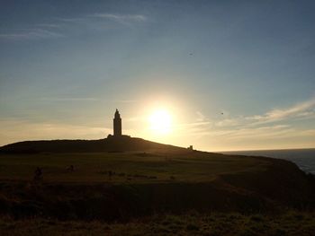 Silhouette of lighthouse on landscape