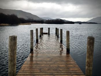 Wooden pier over lake against sky