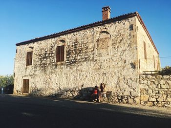 View of old building by road against sky