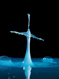 Close-up of water splashing over black background