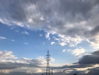 Low angle view of silhouette electricity pylon against sky