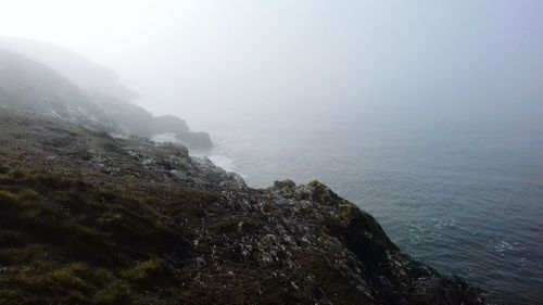 Scenic view of sea and mountains against sky