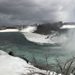 Scenic view of waterfall against sky during winter
