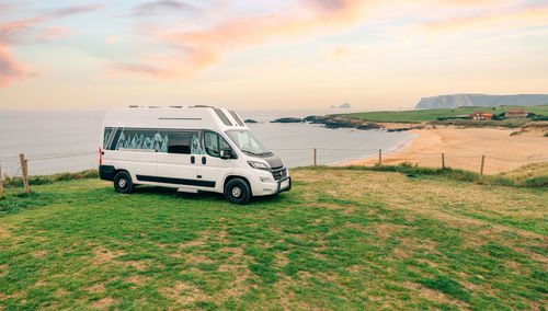 Camper van parked next to beach at summer