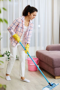 Portrait of young woman standing on floor at home