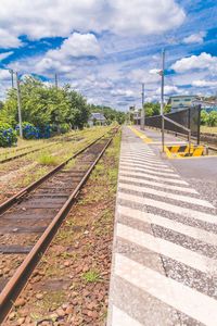 Railway tracks against cloudy sky