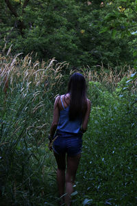 Rear view of woman walking on grass