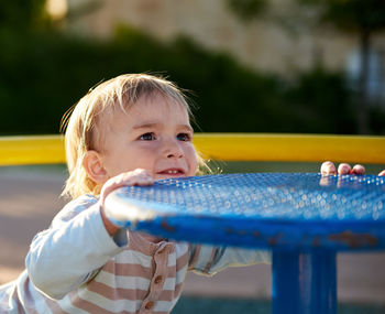 Close-up of boy holding play equipment at playground