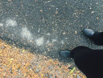 Low section of man standing on road