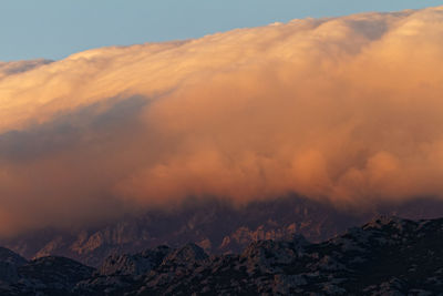 Scenic view of clouds above velebit  mountains against sky during sunset