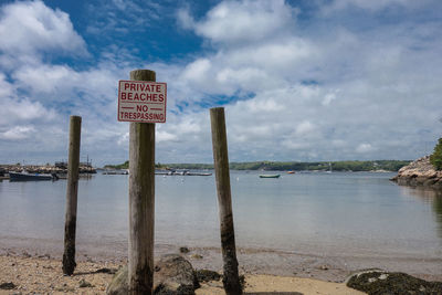 Information sign against cloudy sky