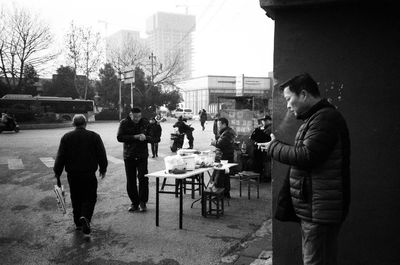 People standing on table by street in city