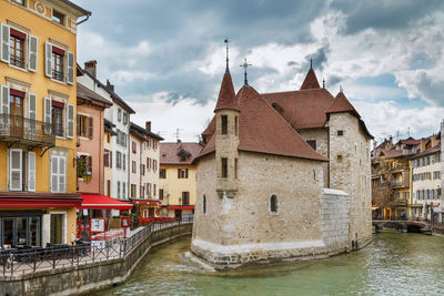 Canal amidst buildings against sky