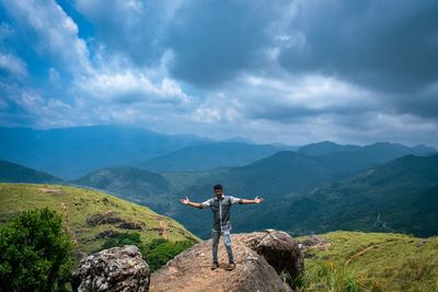 Man standing on mountain against sky