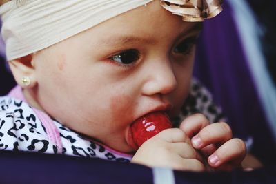 Close-up portrait of baby with lollipop