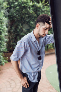 Side view of young man looking at camera