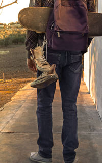 Low section of man standing on footpath