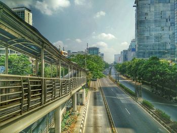 Railroad tracks amidst buildings in city against sky