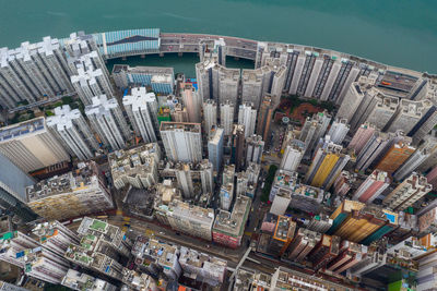 Aerial view of city by sea against sky