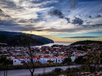 Buildings in town against sky during sunset