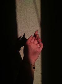 Close-up of hand holding hands against wall