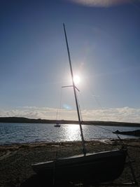 Sailboat moored on sea against sky
