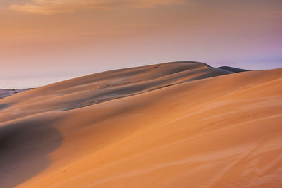 Scenic view of desert against sky during sunset