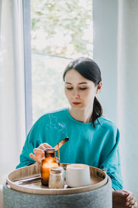 Portrait of young woman drinking coffee at home