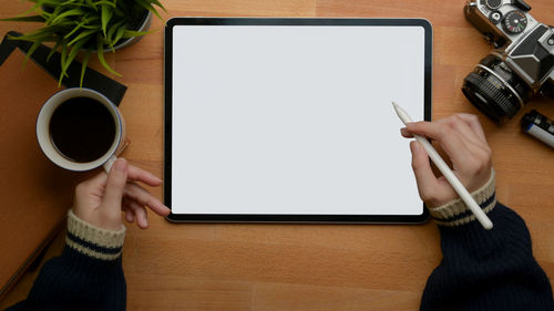 Midsection of woman holding coffee cup on table