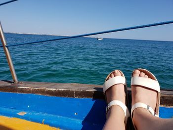 Low section of woman relaxing in swimming pool