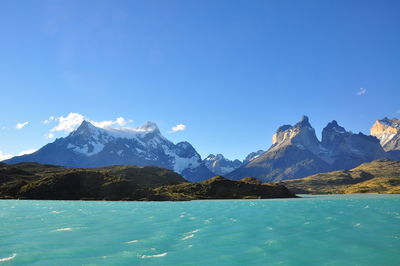 Scenic view of mountains against blue sky