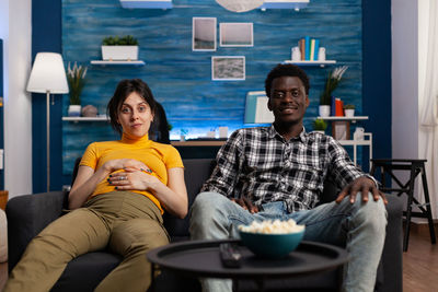 Portrait of couple watching movie at home