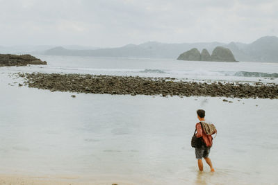 Rear view of man standing on beach