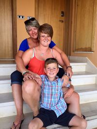 Portrait of smiling family sitting on steps