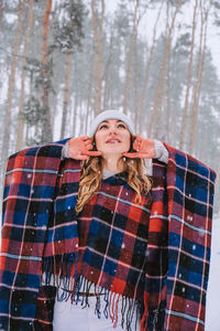 Dancing woman traveling among forest wearing hat and poncho, boho and wanderlust style. winter 