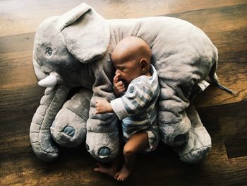 High angle view of father with baby sleeping on hardwood floor