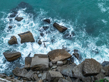 High angle view of rocks on sea shore