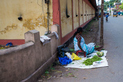 Woman with umbrella on street amidst buildings in city